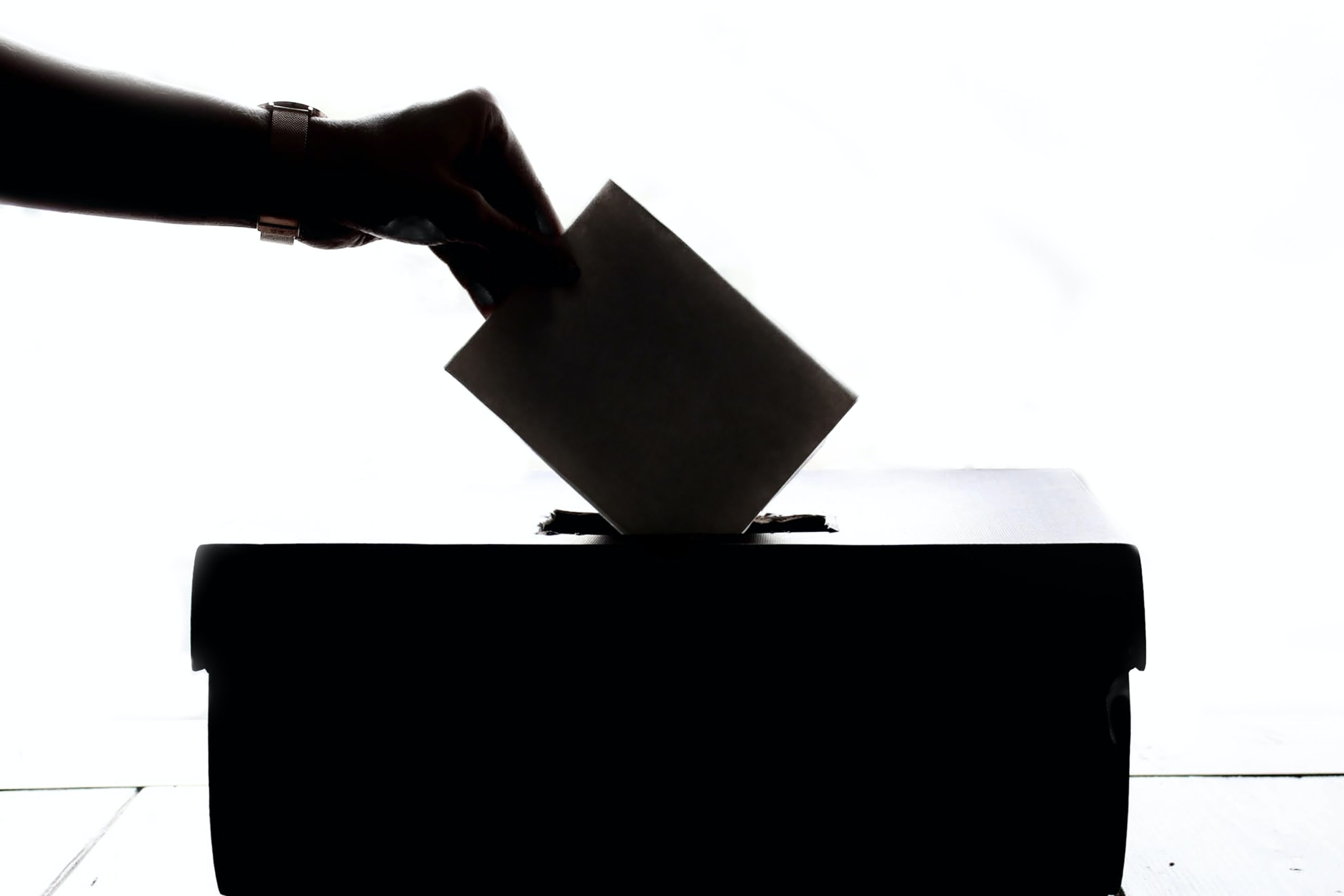 Silhouette of a ballot being dropped into a ballot box