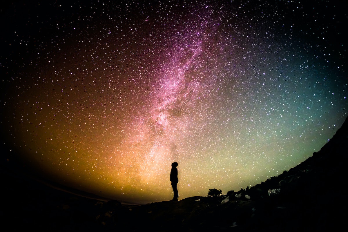 person standing looking up at starry sky