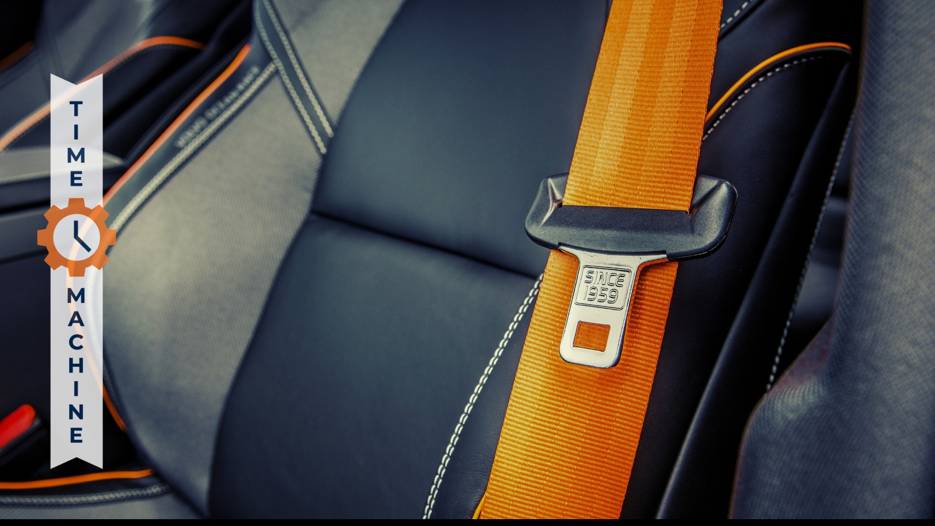 Image of black car seat with orange seat belt across the middle